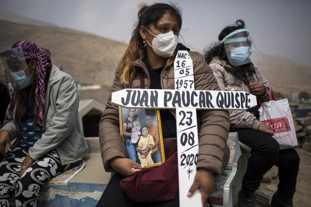 Ruth Morales, 36, Center, Waits For The Arrival Of The Coffin Of Her Husband, Juan Paucar Quispe, 63, Who Died From Covid 19 Complications, During His Burial At A Cemetery In Carabayllo, Lima, Peru