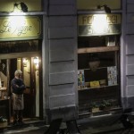 The Owner Of A Restaurant Stands In The Doorway Of The His Establishment In The Naviglio Grande District, In Milan, Italy, Friday, Oct. 23
