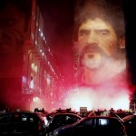 People Light Flares As They Gather Under A Mural Depicting Soccer Legend Diego Maradona, In Naples, Italy, Wednesday, Nov. 25, 2020