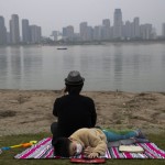 A Child Wearing A Mask To Protect Against The Coronavirus Rests On The Bank Of The Yangtze River In Wuhan In Central China's Hubei Province On April 16, 2020