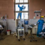 A Worker Wearing Protective Gear Cleans A Window As A Nurse Tends To A Patient Inside The Intensive Care Unit For People Infected With The Coronavirus At The 2 De Mayo Hospital In Lima, Peru