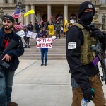 Men Carry Rifles Near The Steps Of The State Capitol Building In Lansing, Mich., On April 15, 2020