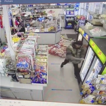 man with a pole trashing an Asian-owned convenience store