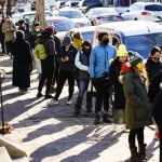 City residents wait in a line extending around the block to receive free at-home rapid COVID-19 test kits in Philadelphia, Monday, Dec. 20, 2021. (AP Photo/Matt Rourke
