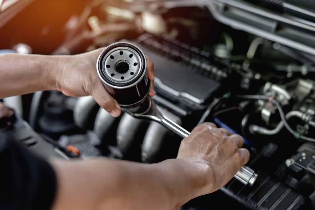 Close,up,oil,filter,of,car,and,wrench,in,hand
