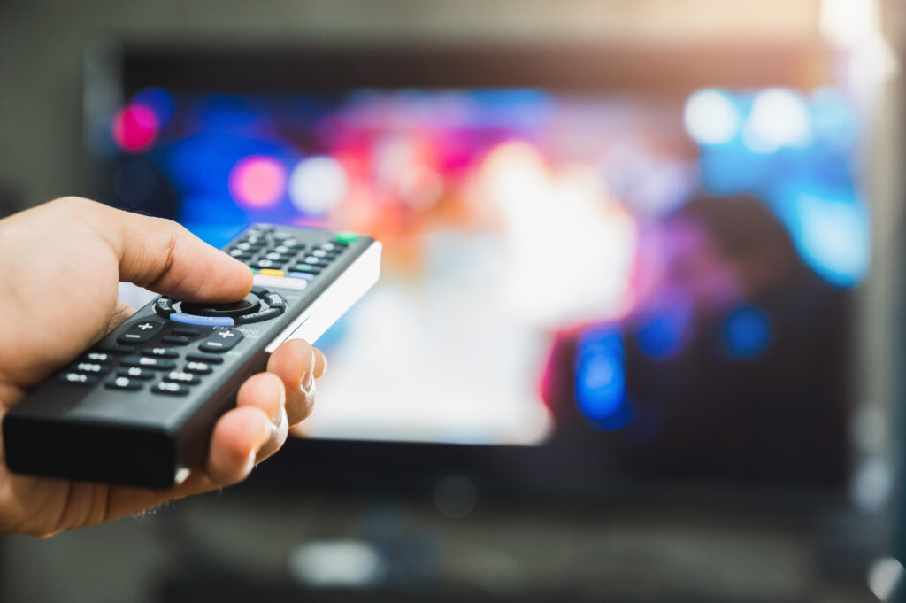 Young Man Holding Television Remote Control. Hands Pointing To T