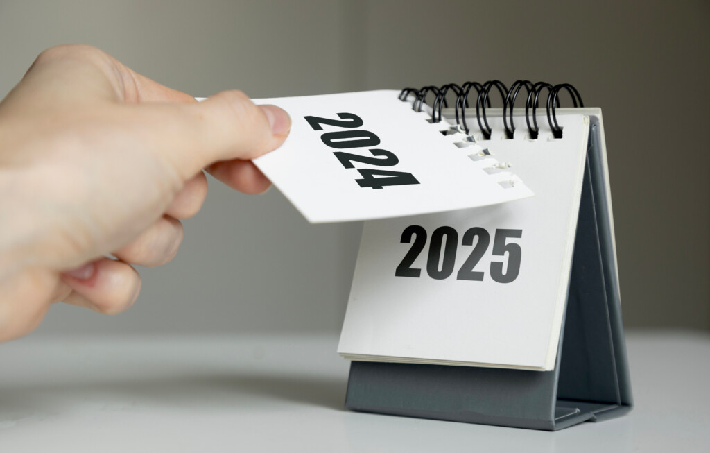 A Woman's Hand Turns Over A Calendar Sheet. Year Change From 2024 To 2025.