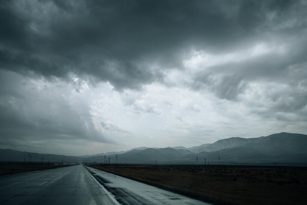 Gray Clouds Over Mountains And An Empty Road On A Cold Rainy Day