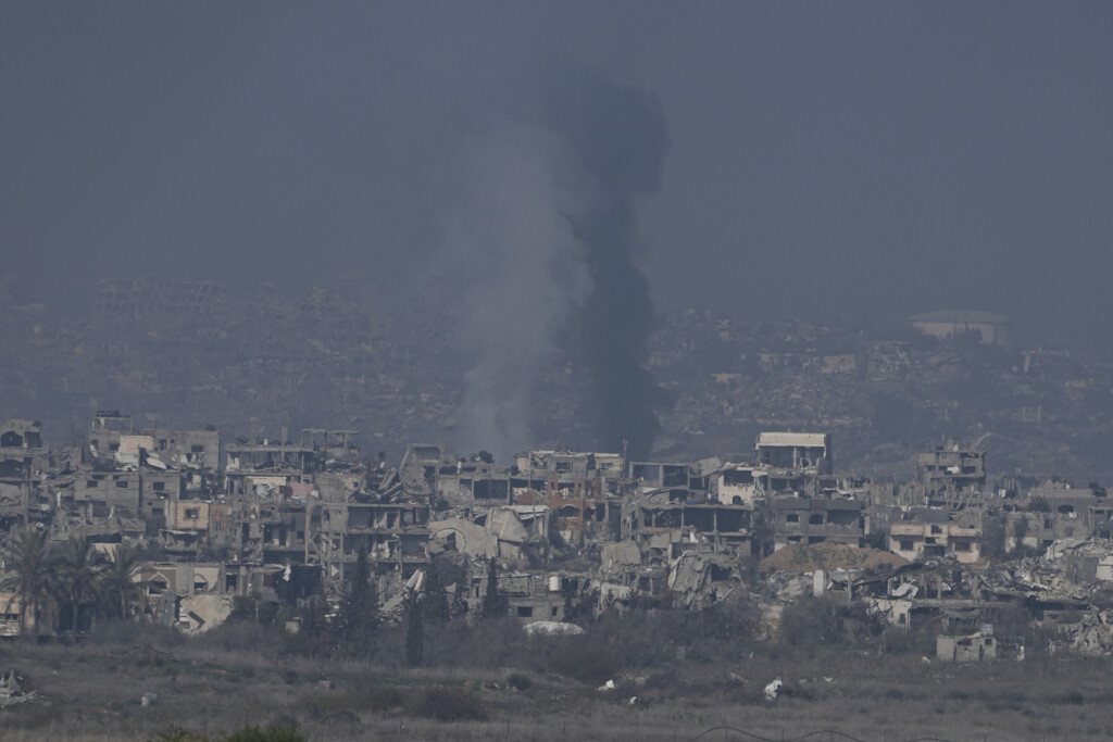 Smoke rises behind destroyed buildings by Israeli bombardments as seen inside the Gaza Strip from southern Israel, Thursday, Jan. 16, 2025. (AP Photo/Tsafrir Abayov)