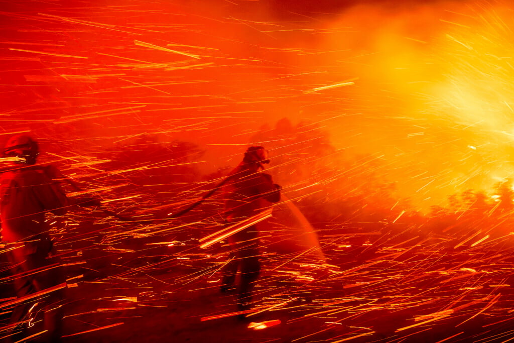 Firefighter Joshua Cari sprays water while battling the Lilac Fire near the Bonsall community of San Diego County, Calif., on Tuesday, Jan. 21, 2025. (AP Photo/Noah Berger)