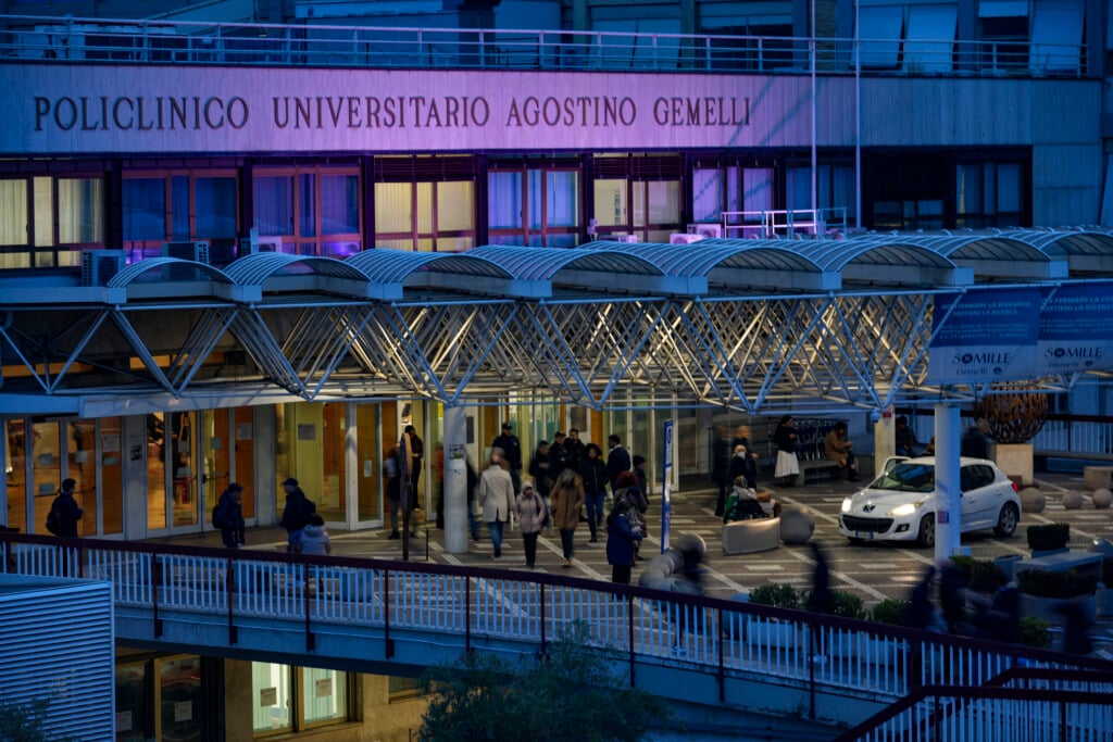 People walk in front of the main entrance of the Agostino Gemelli Polyclinic in Rome, Wednesday, Feb. 19, 2025, where the Pontiff is hospitalized since Friday, Feb. 14. (AP Photo/Andrew Medichini)