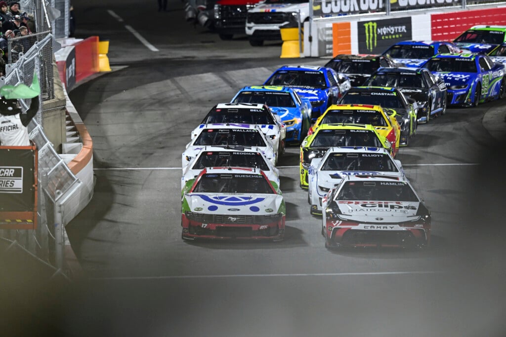 Denny Hamlin (11) and Chris Buescher (17) lead a pack of cars to a green flag during a NASCAR Cup Series auto race at Bowman Gray Stadium, Sunday, Feb. 2, 2025, in Winston-Salem, N.C. (AP Photo/Matt Kelley)