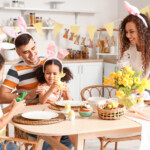 Happy Family At Dining Table In Kitchen On Easter Day
