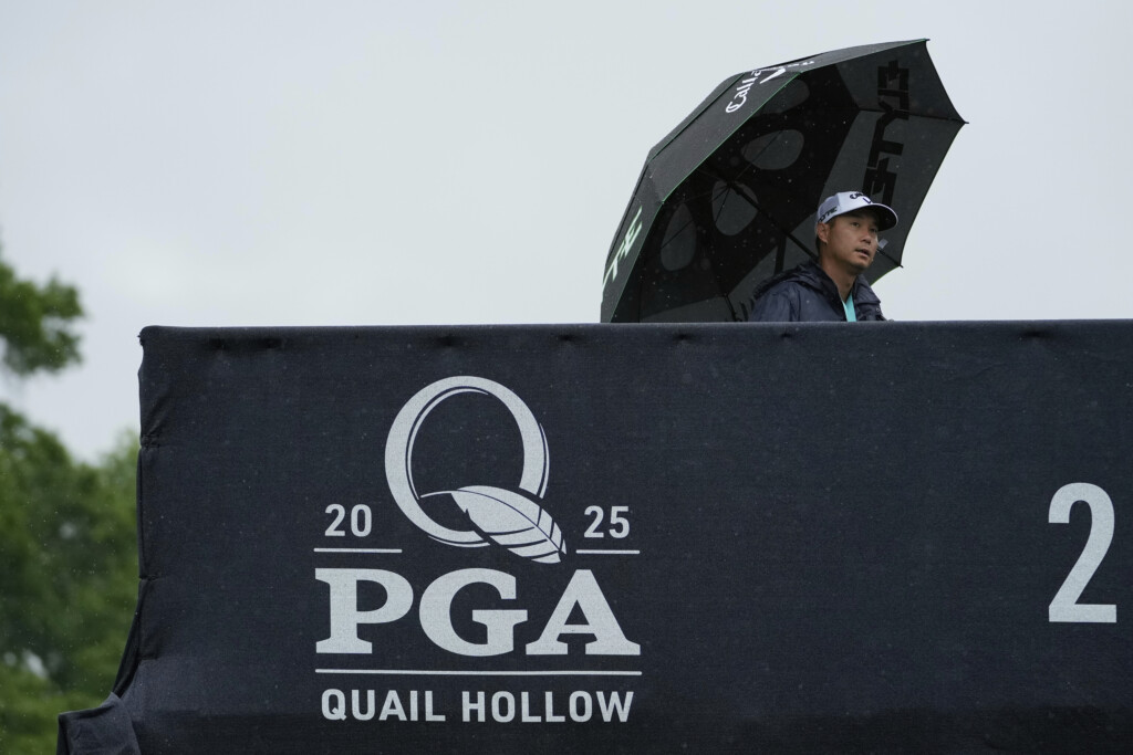 A person walks in the rain over a pedestrian bridge during a practice round for the PGA Championship golf tournament at the Quail Hollow Club, Monday, May 12, 2025, in Charlotte, N.C. (AP Photo/Matt York)