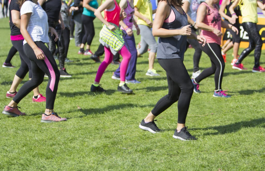 Group Of Young Girls Exercising Fitness With Dancing In The City Park