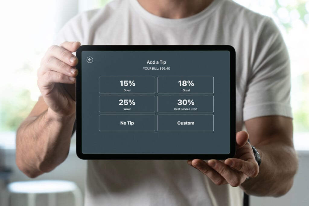Man Holding A Tablet With Tipping Screen Inside A Restaurant