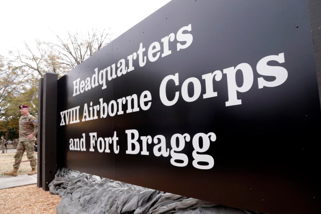A soldier stands beside the sign that was unveiled when Fort Liberty was rededicated as Fort Bragg during a ceremony on base, Friday, March 7, 2025, (AP Photo/Chris Seward)