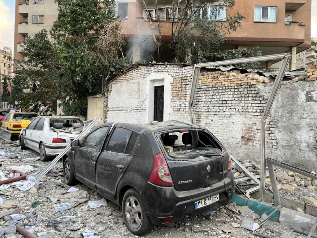 Debris from an apartment building is seen on top of parked cars after a strike in Tehran, Iran, early Friday, June 13, 2025. Israel attacked Iran's capital early Friday, with explosions booming across Tehran.(AP Photo/Vahid Salemi)