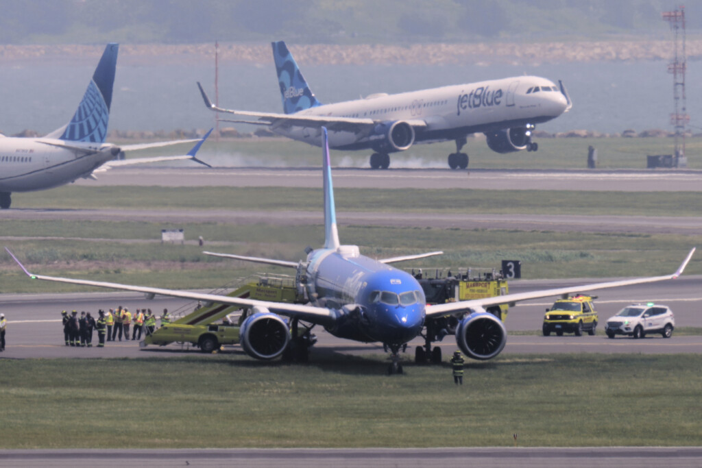 Emergency responders surround a JetBlue plane which rolled off a runway onto a grass area while landing at Logan Airport, Thursday, June 12, 2025, in Boston. (AP Photo/Charles Krupa, Pool)