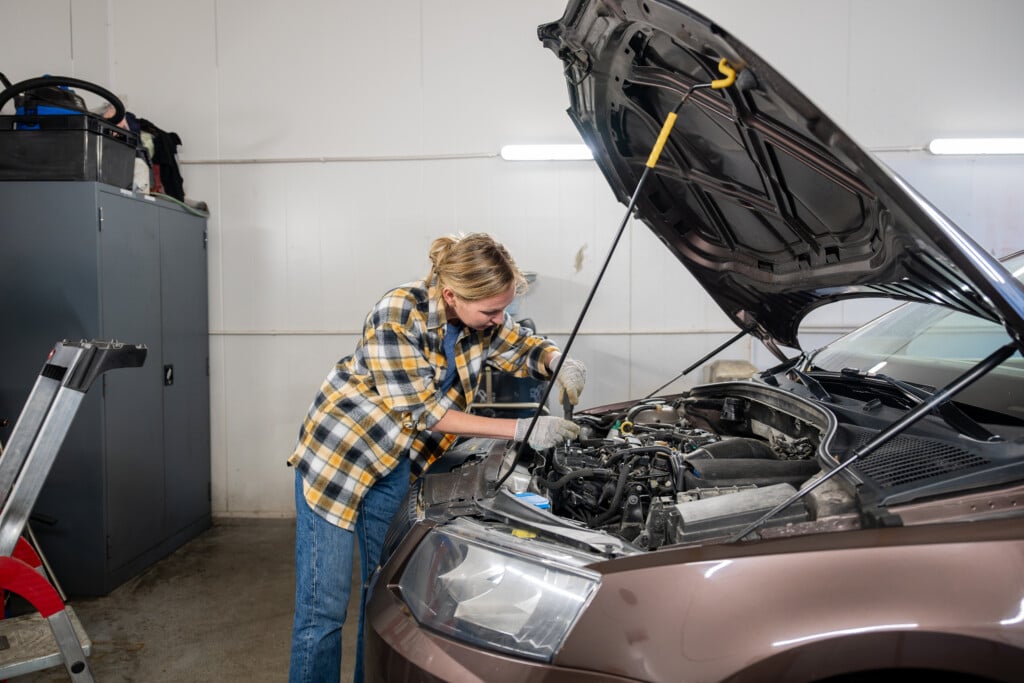 Female Mechanic Working On A Car In Garage