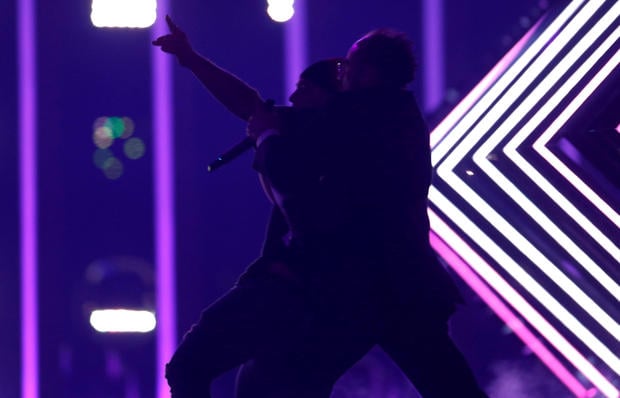 Security subdues a person who invaded the stage as United Kingdom's SuRie performed "Storm" during the Grand Final of Eurovision Song Contest 2018 at the Altice Arena hall in Lisbon
