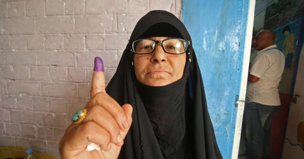 An Iraqi woman shows her ink-stained index finger after voting at a polling station in the southern city of Basra on May 12