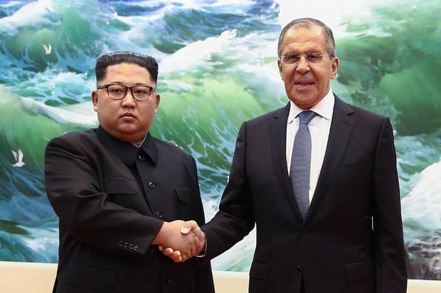 Russian Foreign Minister Sergei Lavrov (R) shakes hands with North Korean leader Kim Jong Un during a meeting in Pyongyang on May 31