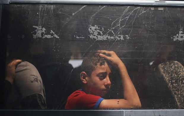 A Palestinian boy looks out a bus window as he waits to travel into Egypt through the Rafah border crossing