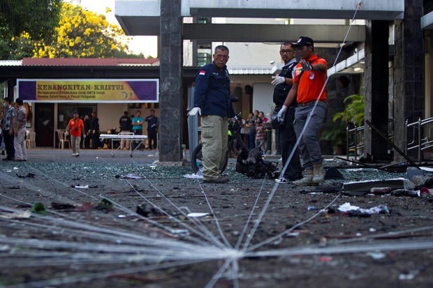 Police forensic team examine the scene of a bomb at a church in Surabaya