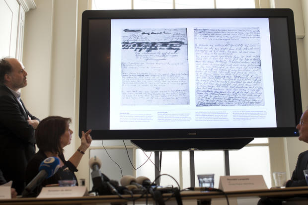 A video shows the text underneath two taped off pages from Anne Frank's diary during a press conference at The Anne Frank Foundation's office in Amsterdam