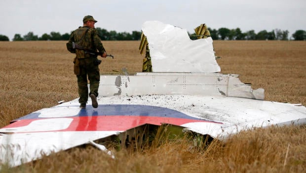 An armed pro-Russian separatist stands on part of the wreckage of the Malaysia Airlines Boeing 777 plane after it crashed near the settlement of Grabovo in the Donetsk region in this July 17