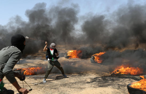 A demonstrator uses a sling to hurl stones at Israeli forces during a protest where Palestinians demand the right to return to their homeland