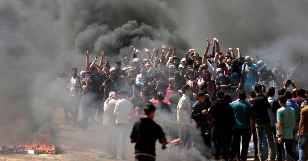 TOPSHOT - Palestinian demonstrators burn tyres near the Gaza-Israel border