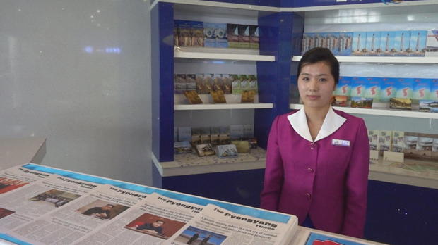ctm-0522-north-korea-airport-ben-tracy-woman-newspapers.jpg 