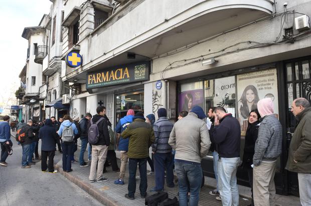 people line up early morning in front of a pharmacy to buy marijuana in Montevideo