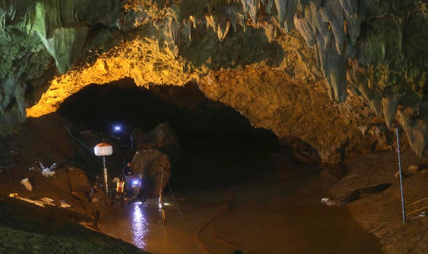 Rescuers talk each other during a search operation at the entrance to a cave complex where 12 soccer team members and their coach went missing