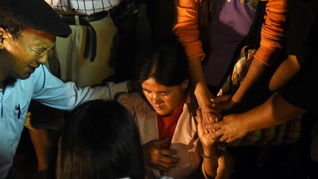 Family members and relatives pray as they keep vigil near the Tham Luang cave in Khun Nam Nang Non Forest Park in Chiang Rai on June 26