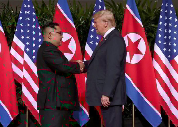 U.S. President Donald Trump shakes hands with North Korean leader Kim Jong Un at the Capella Hotel on Sentosa island in Singapore June 12