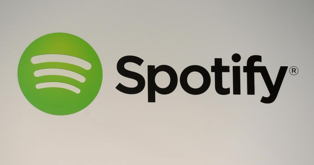 A Spotify logo is seen as founder and CEO Daniel Ek addresses a press conference in New York