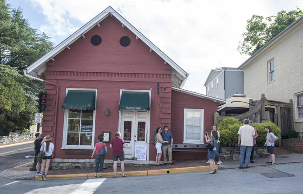 Passersby gather to take photos in front of the Red Hen Restaurant