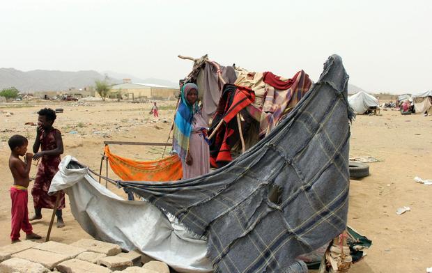 Displaced Yemenis from Hodieda stand outside their shelter at a make-shift camp for displaced people in the northern district of Yemen's Hajjah province on June 19