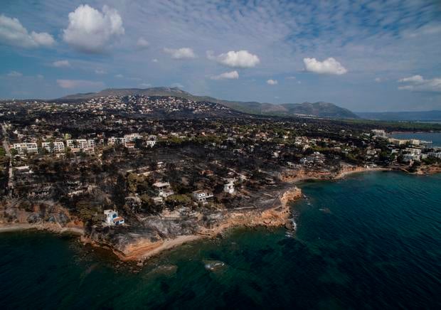 An aerial view shows a burnt area following a wildfire in the village of Mati