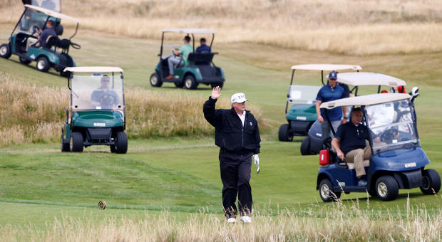 U.S. President Donald Trump gestures as he walks on the course of his golf resort