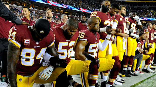 FILE PHOTO: Washington Redskins tight end Niles Paul (84) and linebacker Ryan Anderson (52) and Washington Redskins linebacker Chris Carter (55) kneel with teammates during the playing of the national anthem before the game between the Washington Redskins and the Oakland Raiders at FedEx Field in Landover