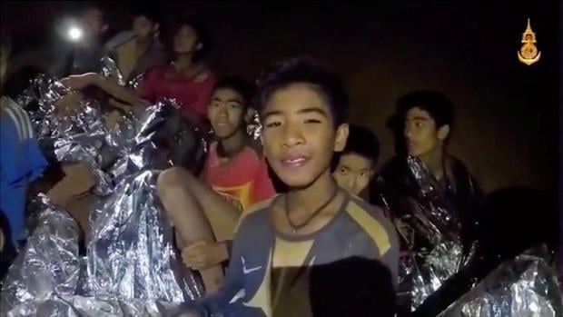 Boys from the under-16 soccer team trapped inside Tham Luang cave covered in hypothermia blankets react to the camera in Chiang Rai