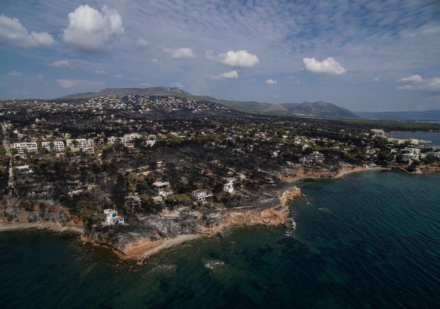 An aerial view shows a burnt area following a wildfire in the village of Mati