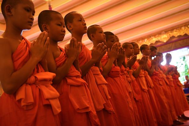 11 members of the "Wild Boars" football team pray during a ceremony to mark the end of their retreat as novice Buddhist monks at the Wat Phra That Doi Tung temple in the Mae Sai district of Chiang Rai province on August 4
