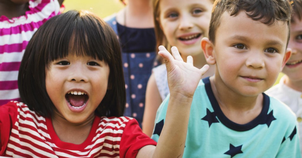 Group of kindergarten kids friends playing playground fun and smiling