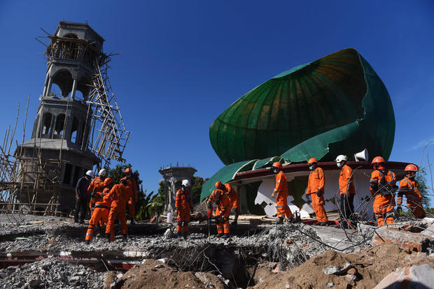 Rescue workers search for victims in a mosque which was damaged in Sunday's earthquake in Tanjung