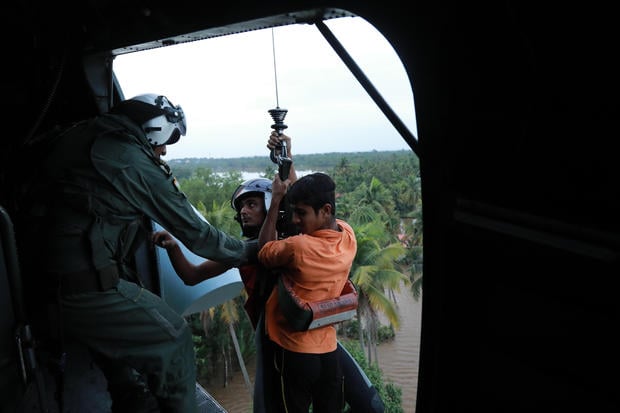 Indian People are airlifted by Navy personnel during a rescue operation at a flooded area in Paravoor near Kochi